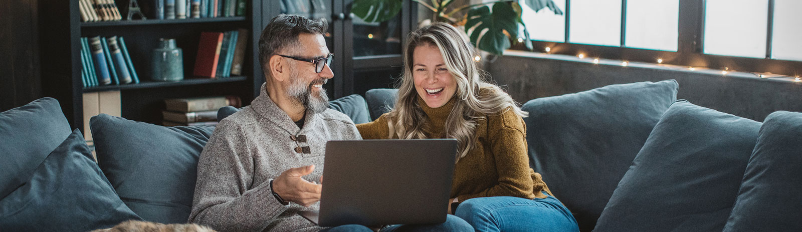 Couple using laptop in living room